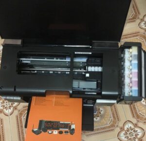 Chuyên gia đang kiểm tra và thay mực cho máy in màu Epson chuyên nghiệp