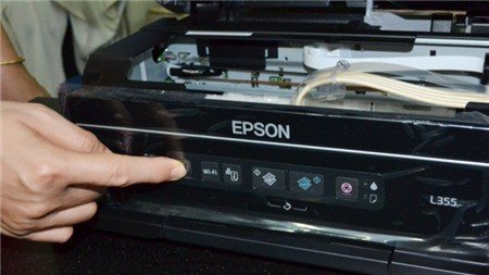 Nhấn giữ nút biểu tượng giọt mực trên máy in Epson để reset hệ thống mực
