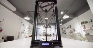 Cận cảnh đầu đùn và cơ cấu ba tay của máy in 3D Delta đang hoạt động