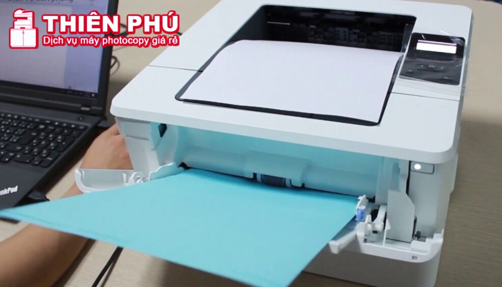 Người dùng đang mở khay giấy của một chiếc máy in HP để chuẩn bị nạp giấy