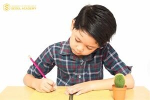 Hình ảnh học sinh tiểu học đang miệt mài luyện viết chữ hoa đẹp