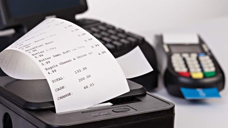 Máy in bill nhiệt màu đen đang in hóa đơn tại quầy thu ngân