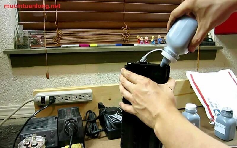 Nạp mực máy in quận 3 Dịch vụ Uy tín Giá Tốt Kỹ thuật viên đang tiến hành nạp mực cho máy in văn phòng tại quận 3 một cách cẩn thận