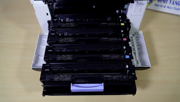 Cận cảnh khay giấy ra của máy in Canon MF643cdw đang thực hiện in 2 mặt tự động