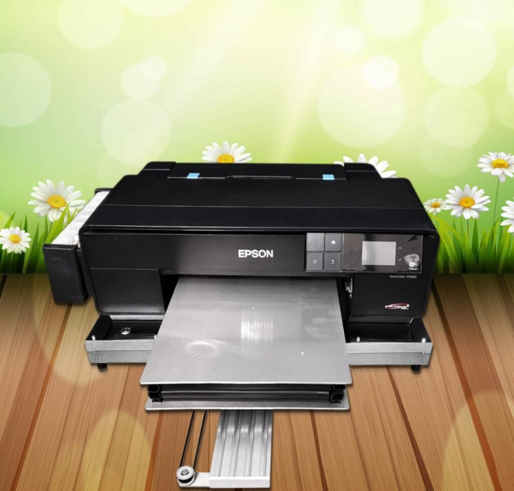 Máy in áo thun Epson P600 đang hoạt động với áo thun được đặt trên bàn in phẳng, sẵn sàng cho quá trình in DTG.