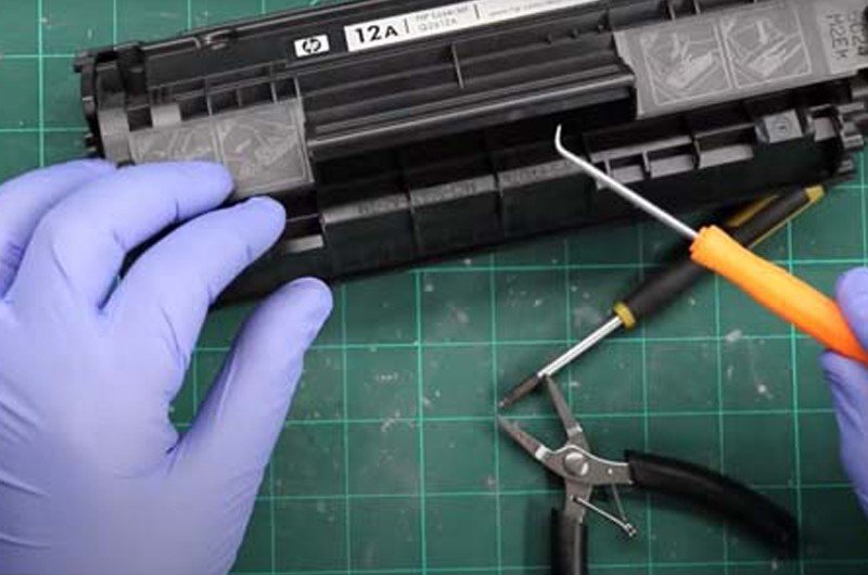 Sử dụng kìm nhọn kéo chốt inox để tháo nắp che hộp mực máy in Canon 2900