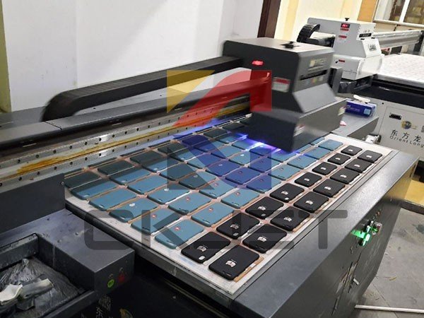 Máy in ốp lưng điện thoại mini hiện đại đang thực hiện in họa tiết lên ốp