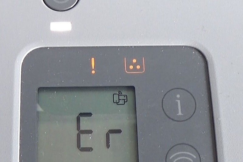 Một người đang thao tác trên máy in để khắc phục lỗi chấm than