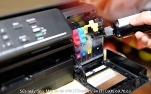 Kỹ thuật viên đang nạp mực máy in quận 5 cho khách hàng