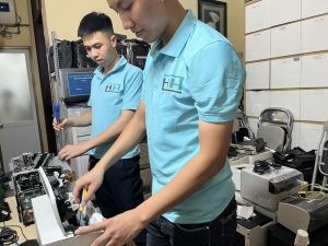 Kỹ thuật viên đang kiểm tra máy in để sửa chữa chuyên nghiệp