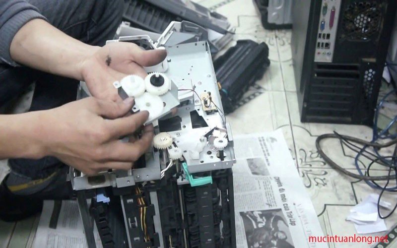 Kỹ thuật viên đang kiểm tra và sửa máy in laser trắng đen tại nhà khách hàng ở TPHCM