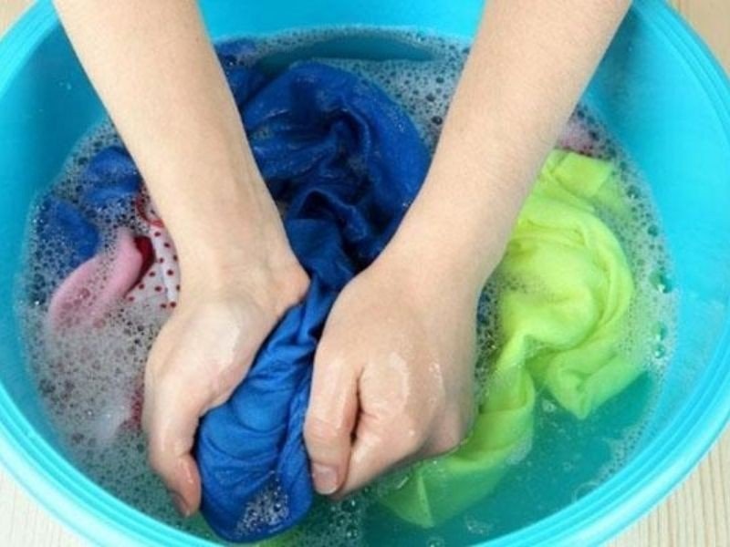 Thao tác vò nhẹ nhàng áo có hình in bằng tay với xà phòng pha loãng