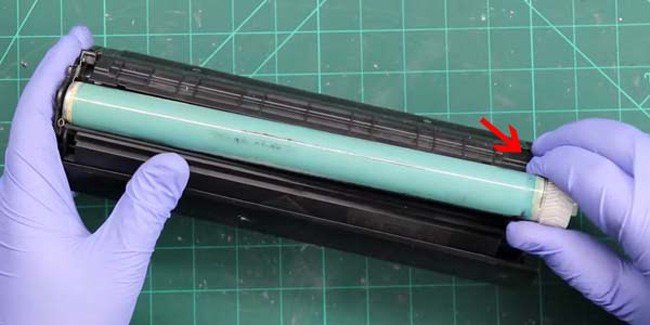 Nhấc trục trống (drum) cẩn thận ra khỏi hộp mực