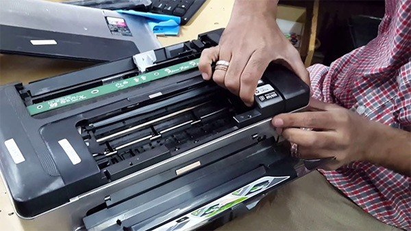 Kỹ thuật viên PC115 đang kiểm tra và sửa chữa máy in chuyên nghiệp tại Hà Nội