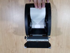 Đặt cuộn giấy in bill mới vào khay máy in, hướng giấy đúng chiều