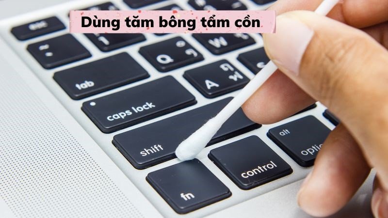 Dùng tăm bông tẩm cồn để làm sạch vết bẩn cứng đầu trên bàn phím laptop