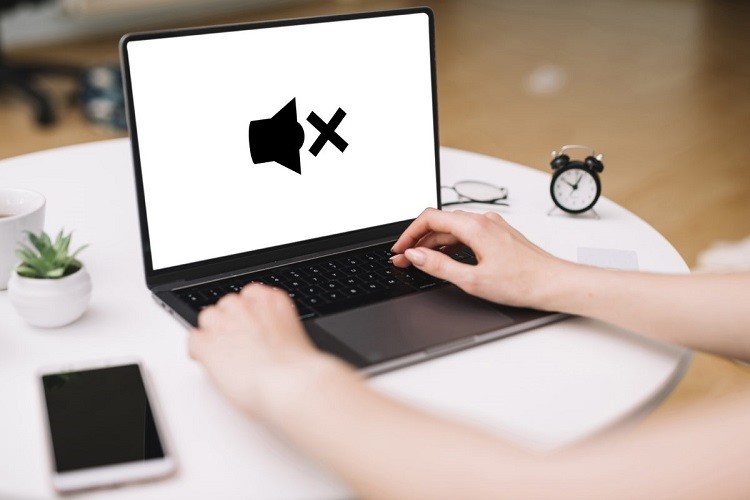 Người dùng đang vệ sinh loa laptop bị nhỏ tiếng bằng cọ mềm