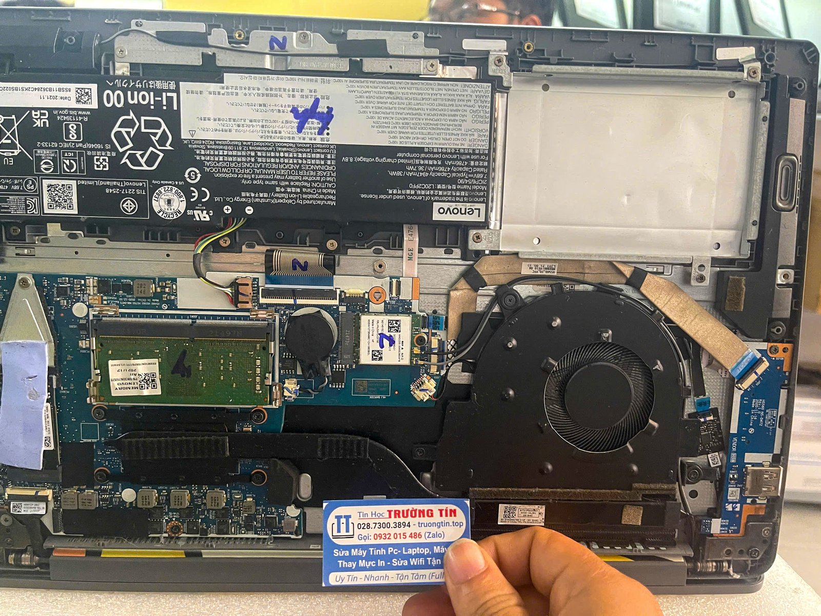 Kỹ thuật viên đang kiểm tra bên trong laptop