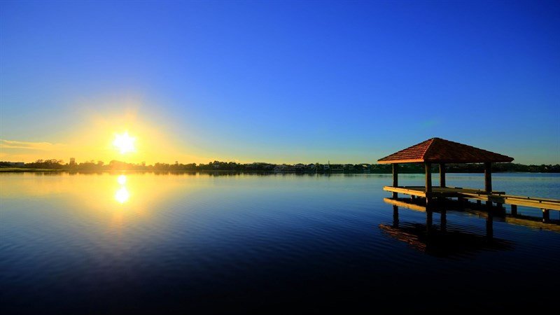 Ảnh nền máy tính bình minh yên bình trên mặt hồ phản chiếu ánh nắng