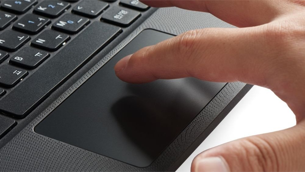 Người dùng đang chạm tay vào touchpad của laptop bị đơ